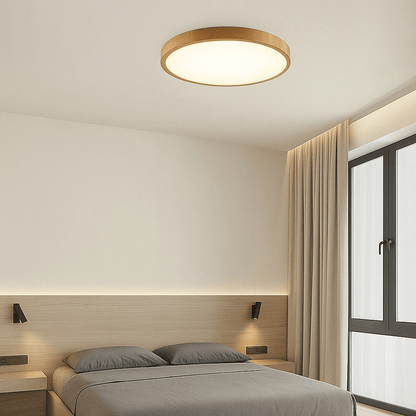 Runde Leuchte mit hellem Holzrahmen an der Decke eines schlichten Schlafzimmers mit Holzkopfteil, grauer Bettwäsche und Fenster. 13