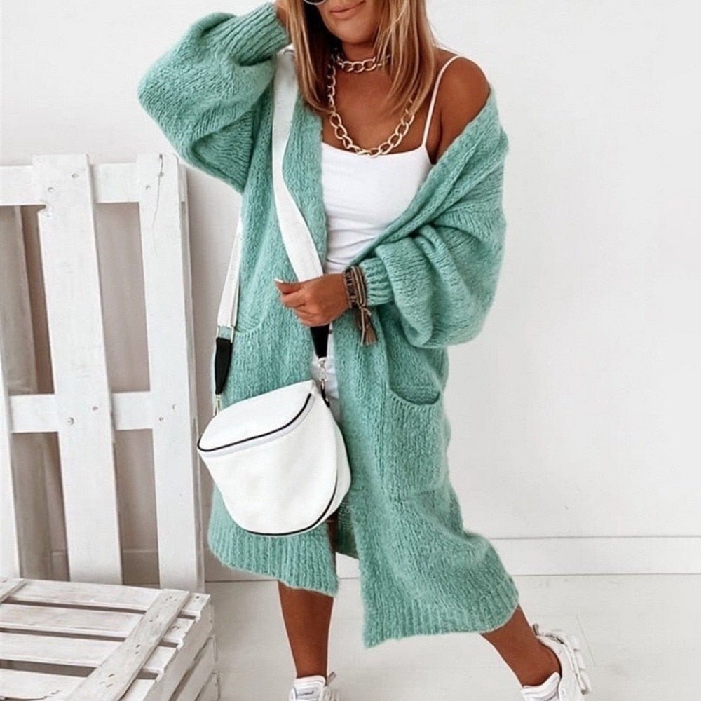 Frau in grüner Strickjacke, weißem Top und Tasche, modisch, bequem, lässiger Stil.