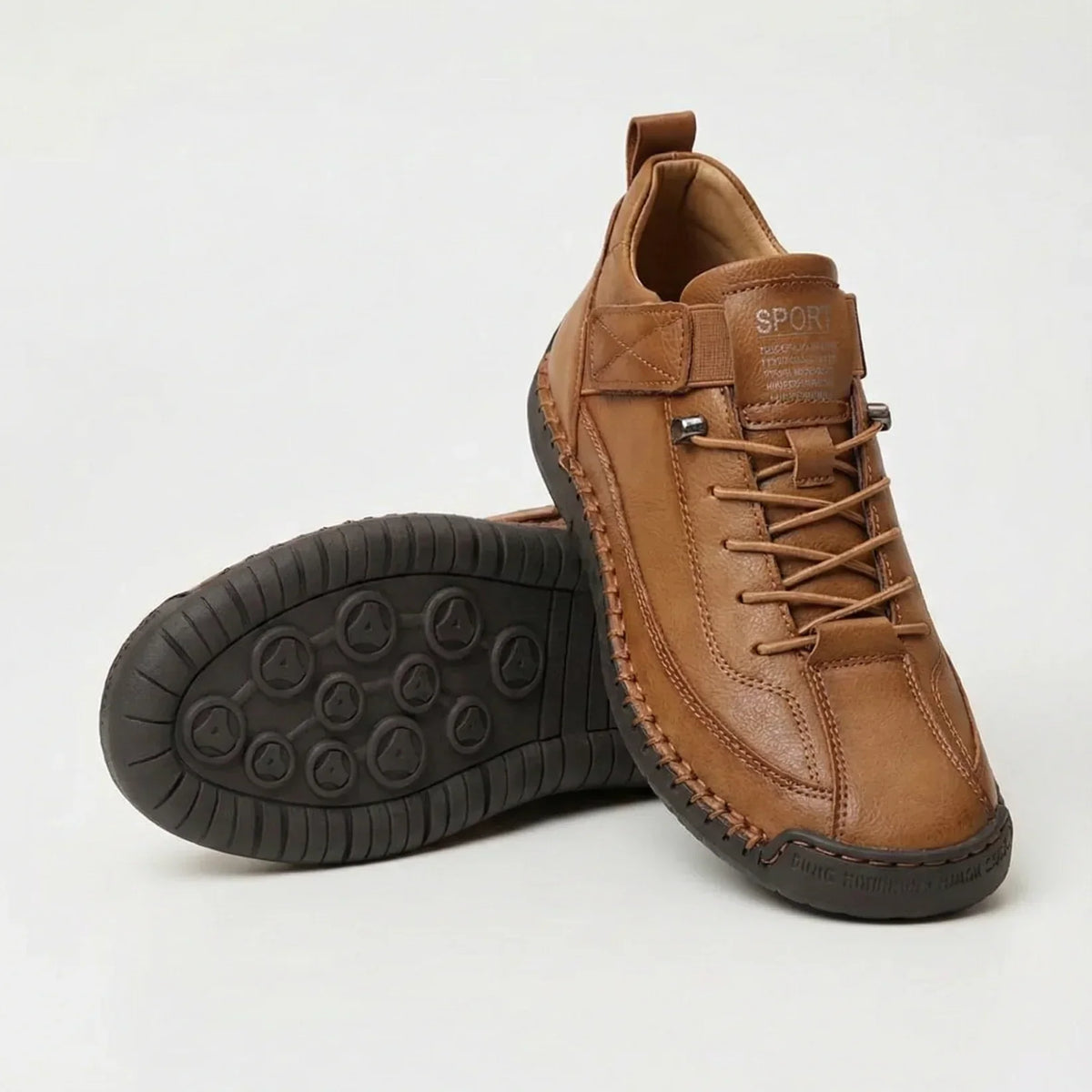 Brauner Ledersneaker mit Schnürung und Zierstichen, ein Schuh gekippt mit dunkler Sohle und rundem Noppenmuster sichtbar. 4