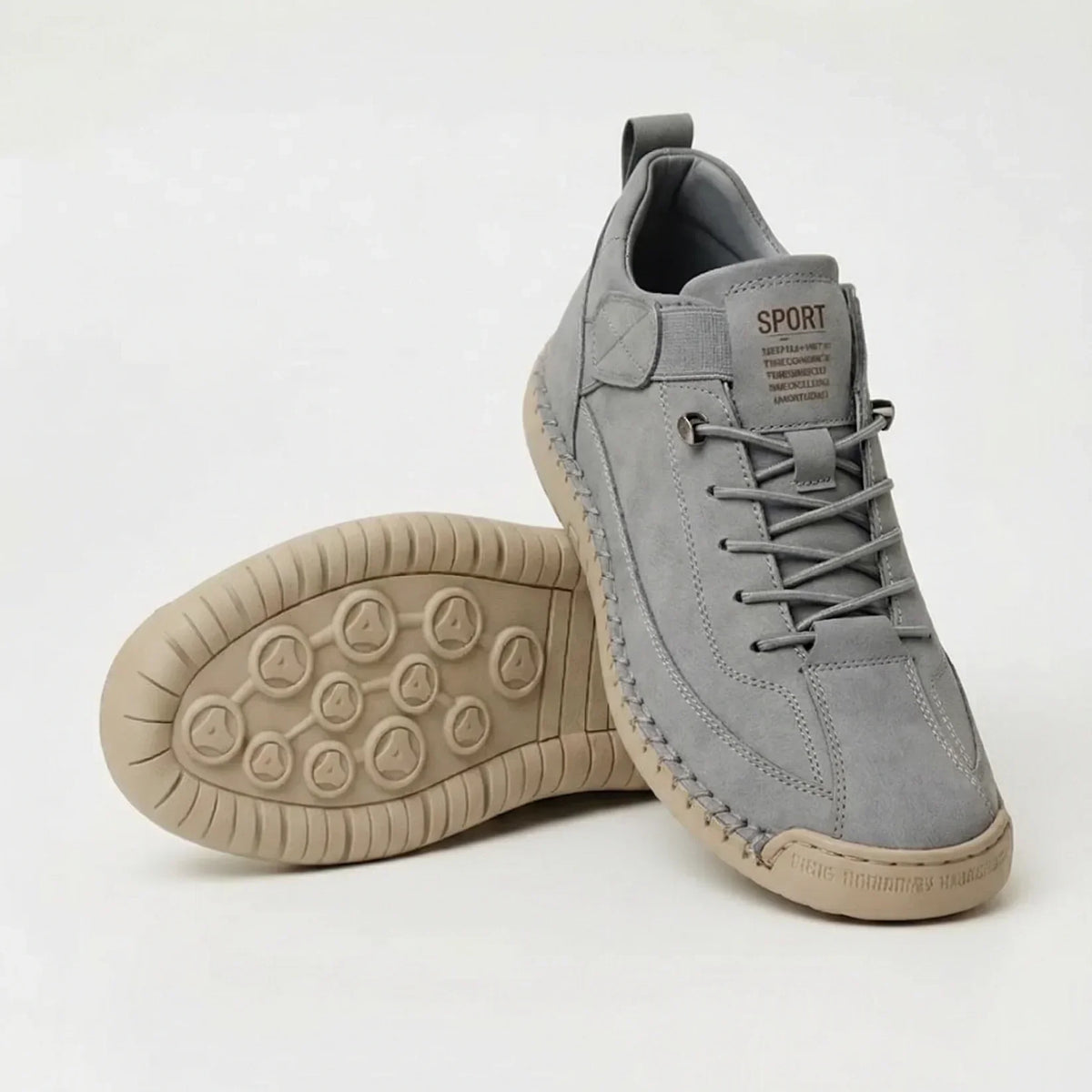 Hellgrauer Sneaker in Wildleder-Optik mit beiger Sohle, ein zweiter Schuh liegt mit dem Noppenprofil nach oben. 8