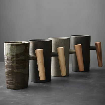 Vier Becher mit Holzgriff nebeneinander gereiht, grün-braun glasiert, schwarz, sandfarben und grau 5