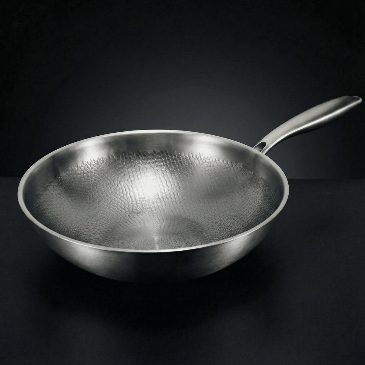Geschmiedete Titan-Wokpfanne mit gebürsteter Metalloberfläche und langem Stielgriff, schräg von vorn.