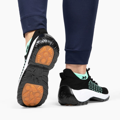 Schwarze orthopädische Stretch-Schuhe mit grünen Akzenten, rutschfeste Sohle, bequemes Design.