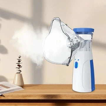 Weißes Inhalationsgerät mit Maske auf einem Holztisch mit feinem Nebel