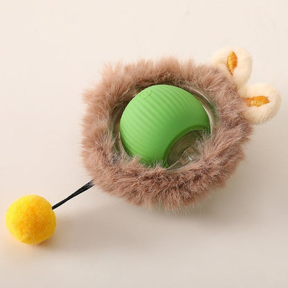 Grüner Ball in braunem Plüschmantel mit zwei cremefarbenen Öhrchen und gelbem Bommel an dünner Schnur, Draufsicht.