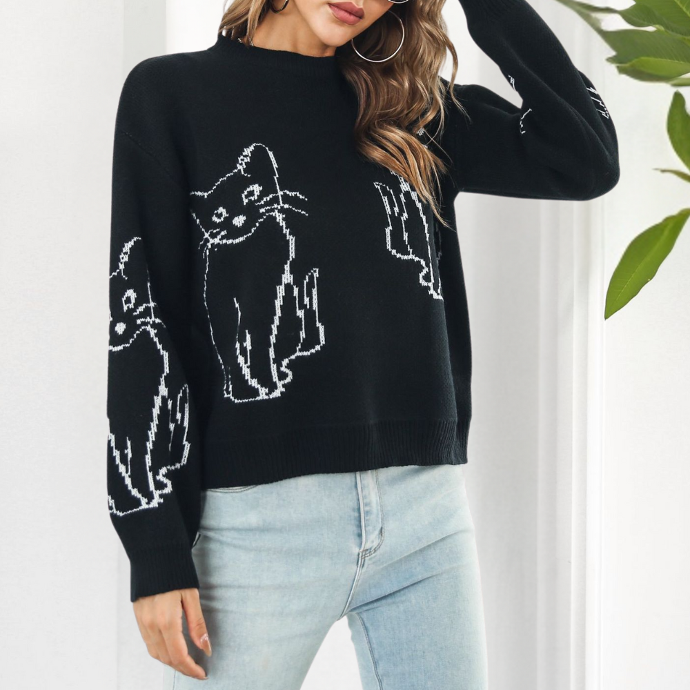Frau trägt schwarzen Pullover mit Katzenmotiv, Damenmode, lässig, Herbst, Strick, Jeans.