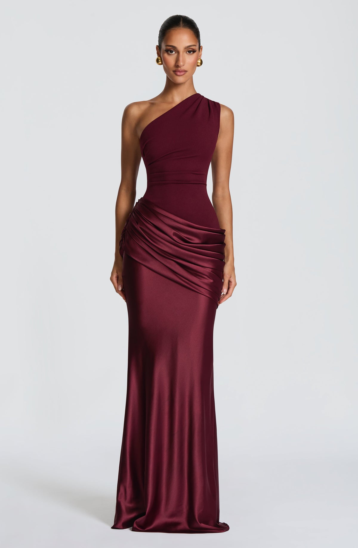 Burgunderrotes Maxikleid mit einer Schulter und üppig gerafftem Satin an der Hüfte, frontal mit goldenen Ohrringen. 13