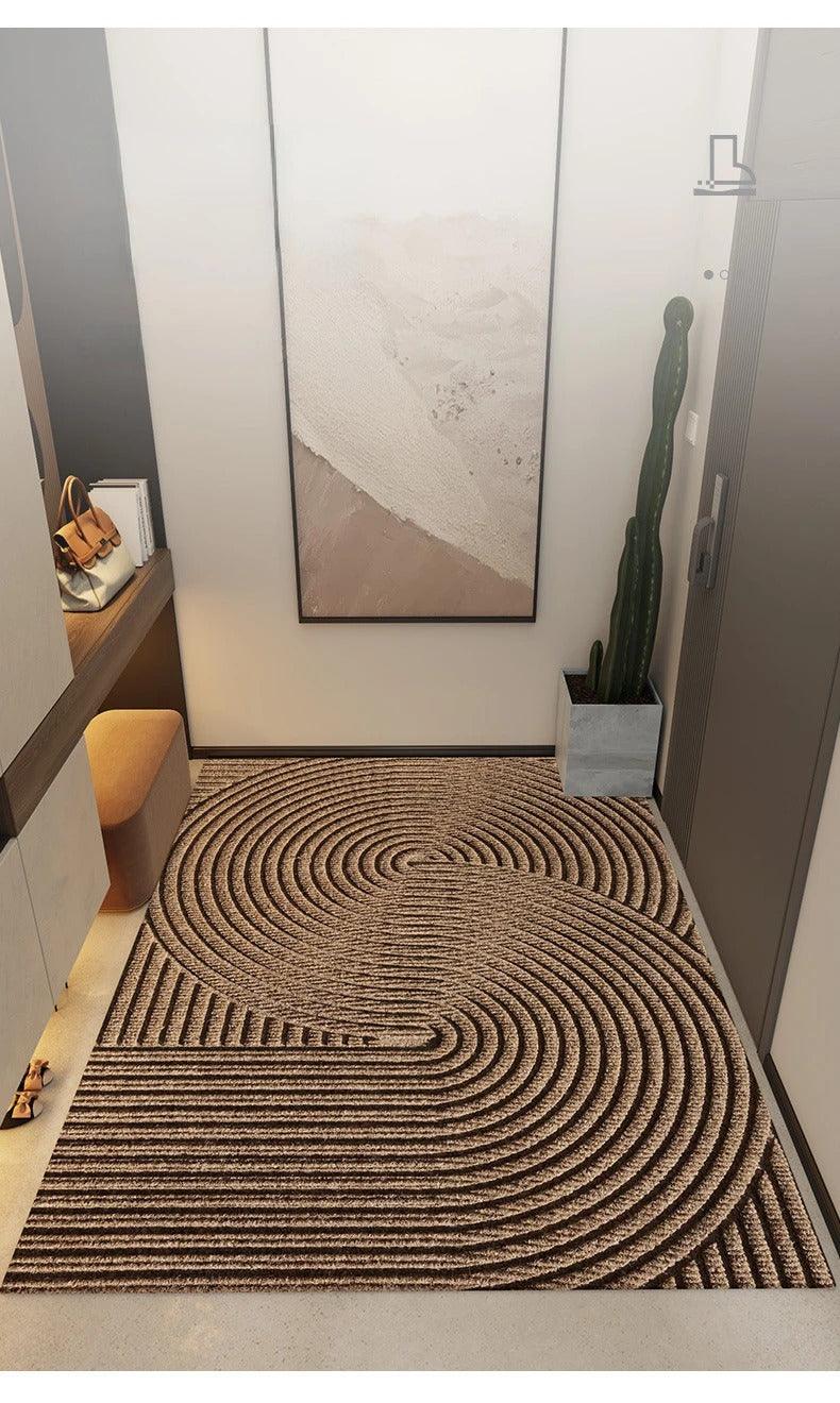 Braune Fußmatte aus Kunststoff mit großem Kreisbogenmuster in einem modernen Flur als weitere Ansicht.