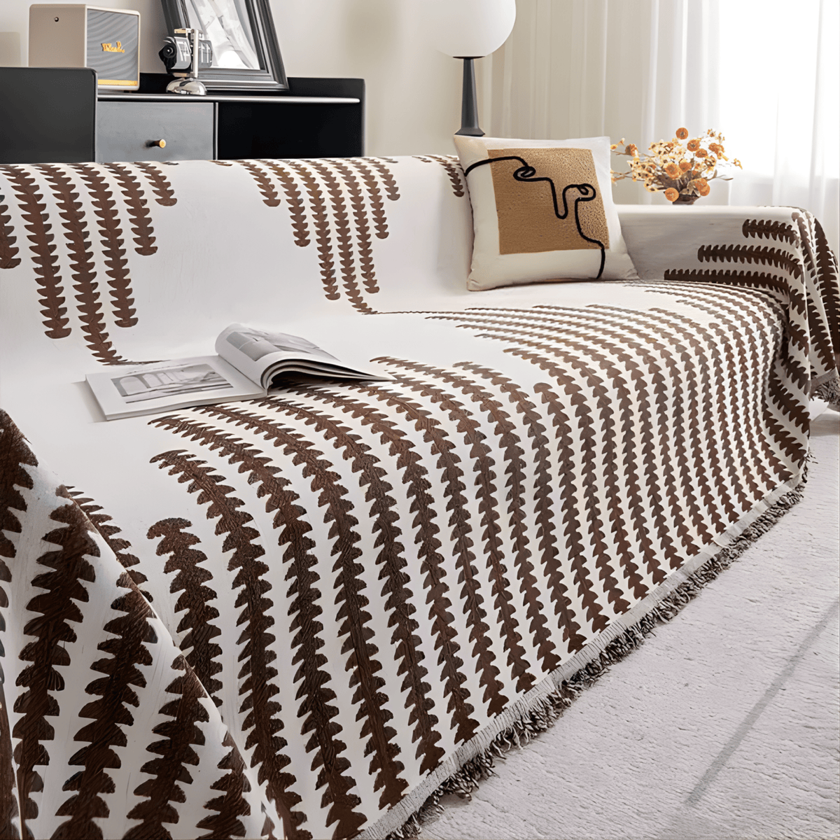 Braun-weißer Sofabezug mit grafischem Muster auf einem Sofa