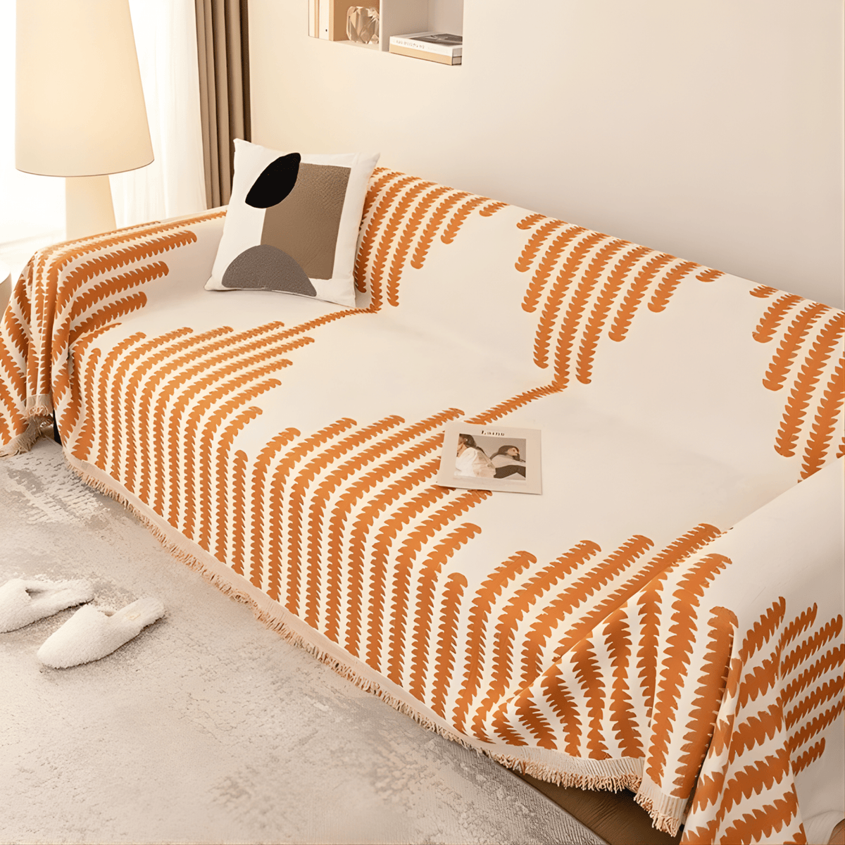 Schwarz-weißer Sofabezug mit Fransenrand, schräg von oben auf einem Sofa