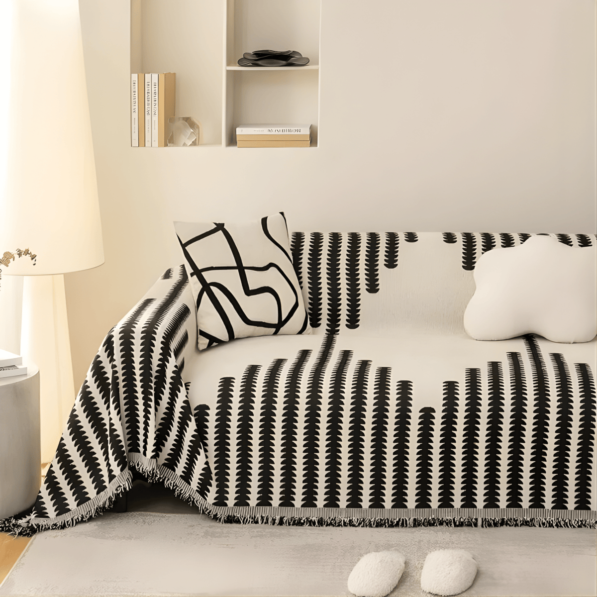 Schwarz-weißer Sofabezug mit grafischem Muster auf einem Sofa im Wohnzimmer