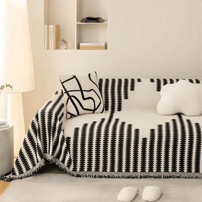 Schwarz-weißer Sofabezug mit grafischem Muster auf einem Sofa im Wohnzimmer