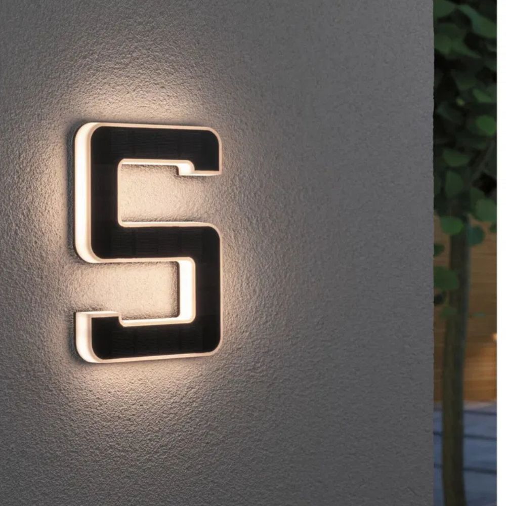 Solarbeleuchtete Hausnummer mit Ziffer 5 in Schwarz und Weiß an einer grauen Wand