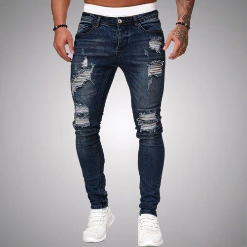 Frontansicht der Jeans mit Rissen an Oberschenkel und Knie in dunklem Marineblau mit weißen Sneakern.