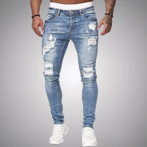 Frontansicht der Slim-Fit-Jeans mit Rissen in hellem, verwaschenem Blau mit weißen Sneakern.