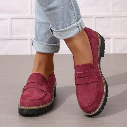 Weinrote Loafer in Wildlederoptik an den Füßen mit hellblauen Jeans.