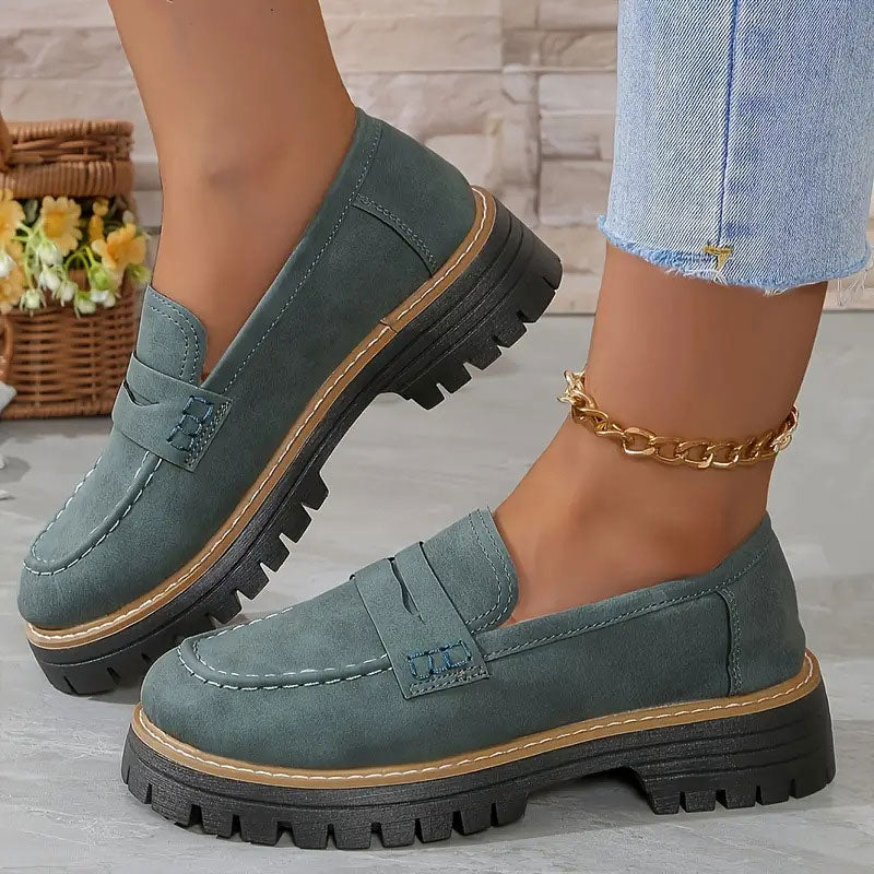 Graugrüne Loafer mit hellbrauner Ziernaht an der Sohle.