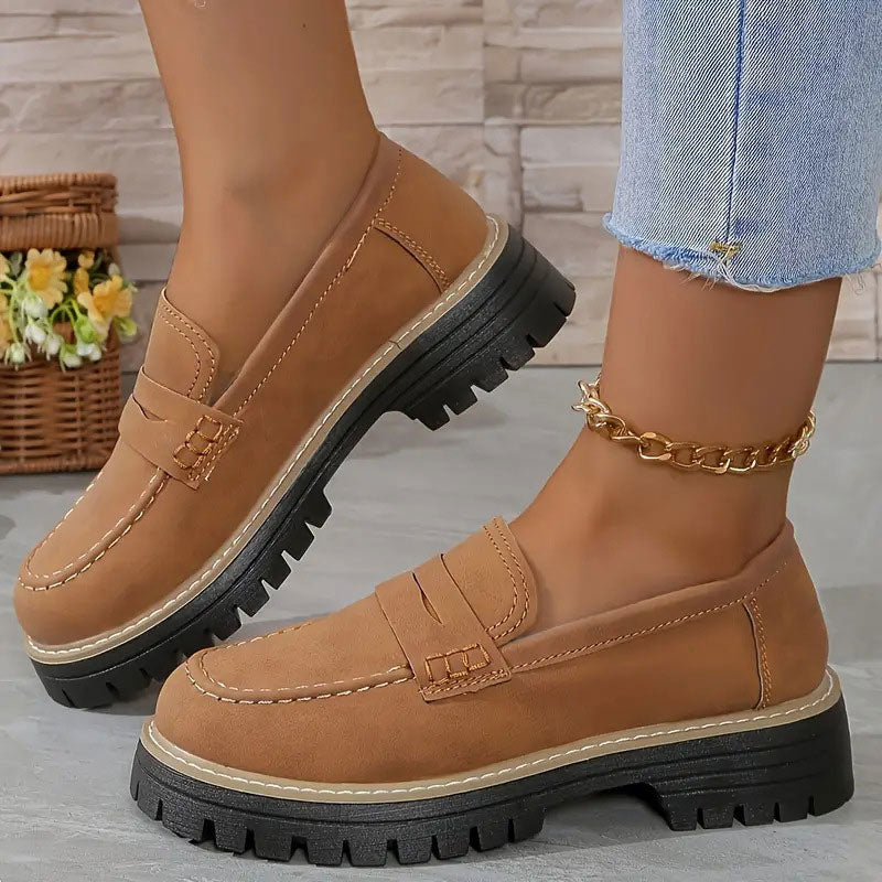 Hellbraune Loafer mit orangefarbener Ziernaht und schwarzer Profilsohle.