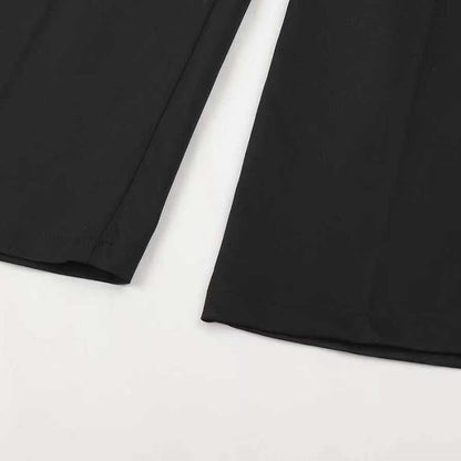Nahaufnahme der Beinabschlüsse einer schwarzen Hose, flach auf weißem Untergrund, mit Saumnaht und Bügelfalte.