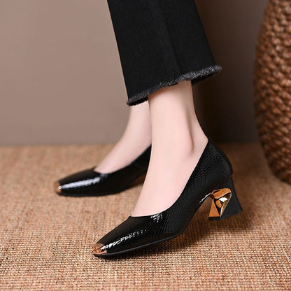 Schwarze glänzende Pumps mit quadratischer Spitze, Seitenansicht am Fuß mit goldfarbenem Metalleinsatz im Absatz.