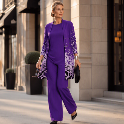 Model in violettem Set auf einer Straße, mit Sonnenbrille und schwarzer Clutch in der Hand, schwarze spitze Pumps dazu. 12