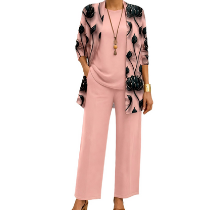 Rosafarbenes Set mit schwarzem Blütenmuster auf dem Cardigan, dazu Rundhalsshirt und weite Hose, vom Model getragen. 2