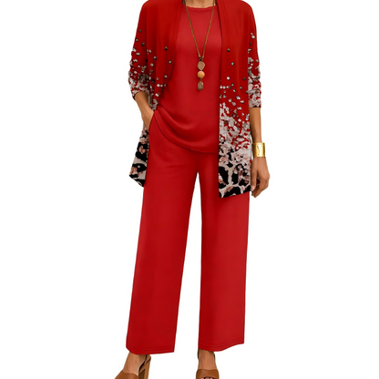 Rotes Set, bei dem der Cardigan zum Saum hin ein weiß-schwarzes Muster mit kleinen Nieten zeigt, dazu Shirt und Hose. 5