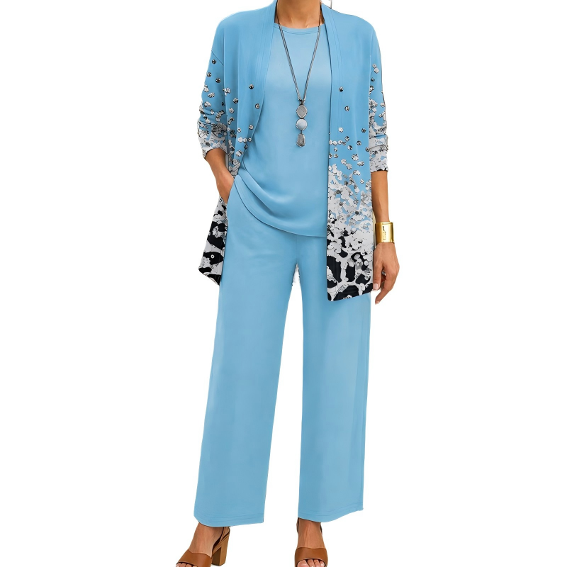 Hellblaues Set mit Cardigan, der zum Saum hin ein Muster aus silbernen Pailletten und schwarzen Flecken zeigt, mit Shirt und Hose. 11