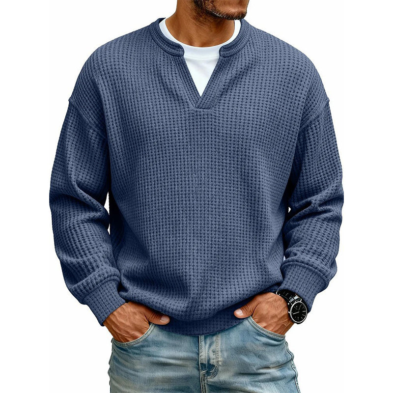 Frontansicht des Waffelstrick-Oberteils in Dunkelblau mit V-Ausschnitt und weißem Shirt darunter, getragen mit Jeans. 13