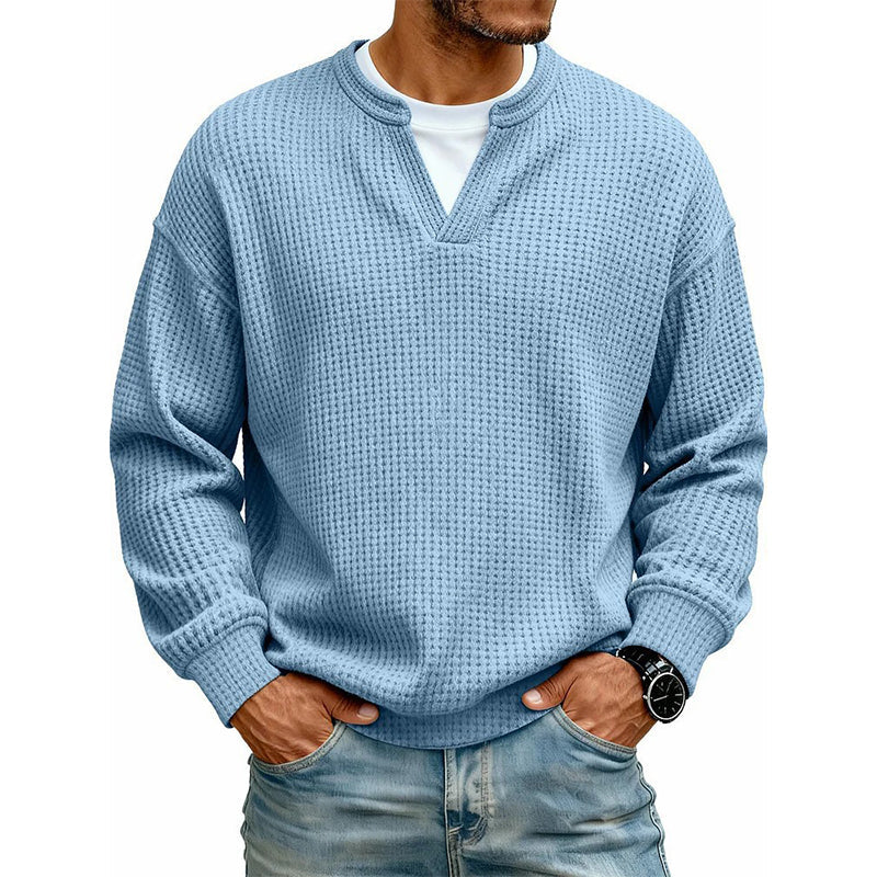 Frontansicht des Waffelstrick-Oberteils in Hellblau mit V-Ausschnitt und weißem Shirt darunter, getragen mit Jeans. 12