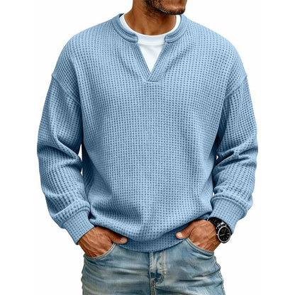 Frontansicht des Waffelstrick-Oberteils in Hellblau mit V-Ausschnitt und weißem Shirt darunter, getragen mit Jeans. 12