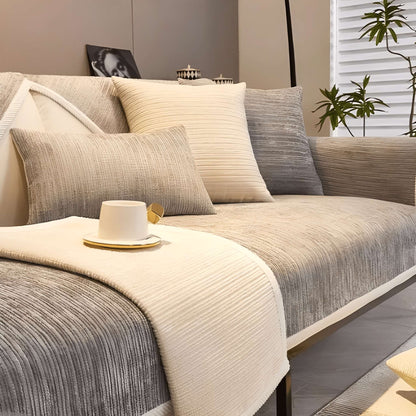 Sofa mit beige-grauem Schutzbezug und weißer Tasse mit Untertasse.