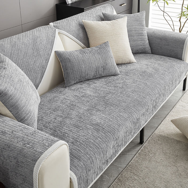 Graues Sofa mit grauer Chenille-Auflage und Kissen im Wohnzimmer.