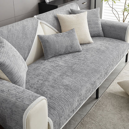 Graues Sofa mit grauer Chenille-Auflage und Kissen im Wohnzimmer.