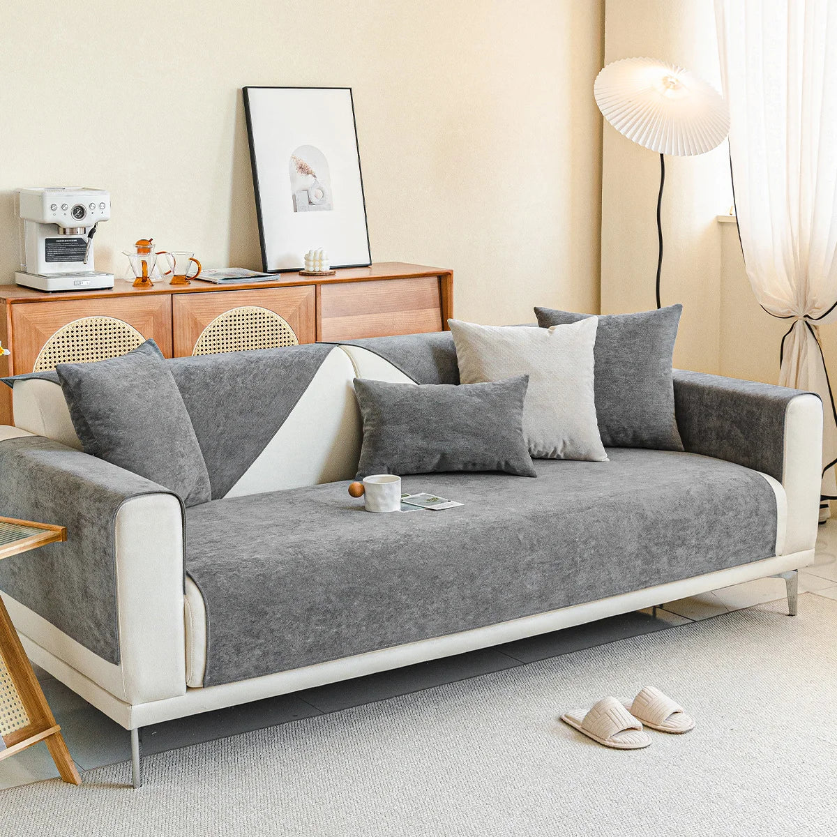 Weißes Sofa mit grauer Chenille-Auflage und mehreren Kissen im Wohnzimmer.
