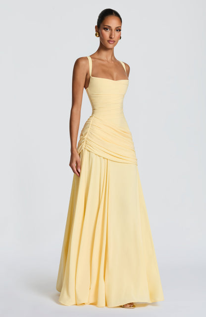 Hellgelbes Maxikleid in Dreiviertelansicht am Model mit fließendem Rock.