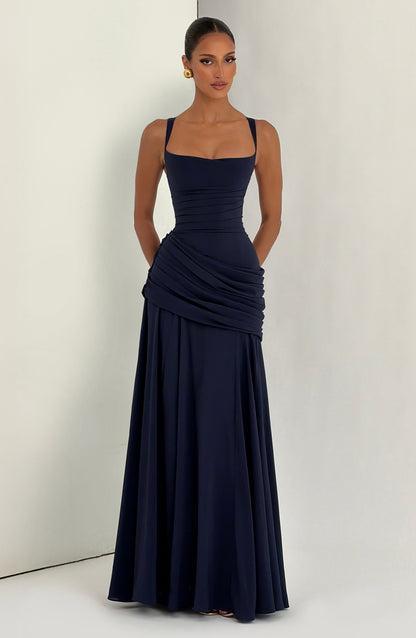Das marineblaue Maxikleid am Model vor hellem Hintergrund, frontal fotografiert.