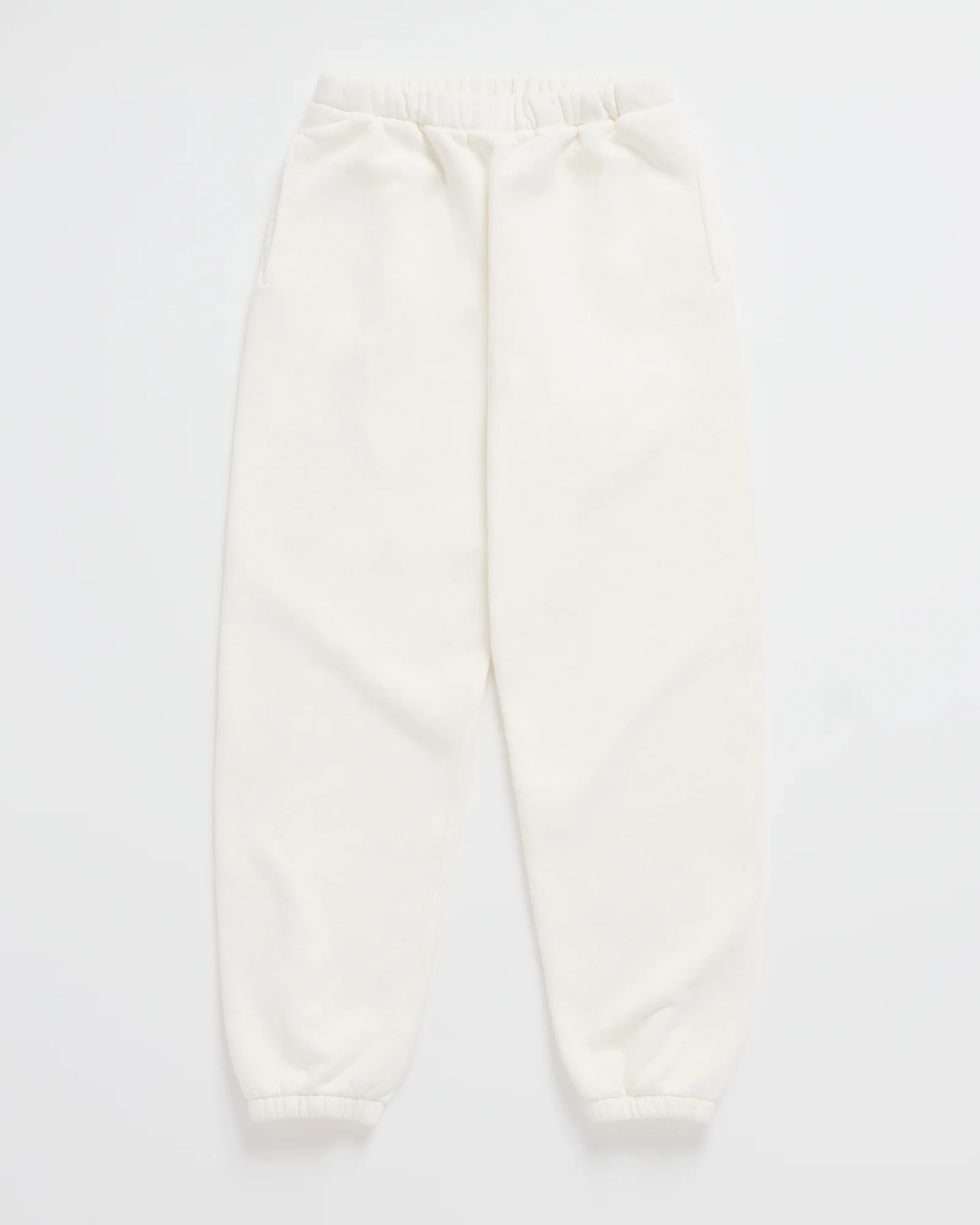 Cremeweiße Jogginghose mit Gummibund, seitlichen Taschen und elastischen Beinabschlüssen, flach ausgelegt. 7
