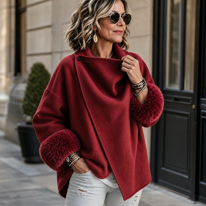 Rote Jacke mit Fellbündchen, Model fasst den drapierten Kragen an und trägt Armbänder 2