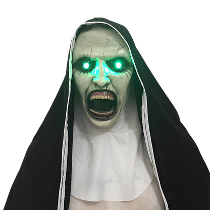 Gruselige Nonnen-Maske mit leuchtend grünen Augen, weit geöffnetem Mund, schwarzem Schleier und weißem Kragen.