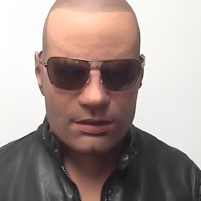 Glatzköpfige Männermaske mit Sonnenbrille, getragen zu einer schwarzen Lederjacke mit Reißverschluss.