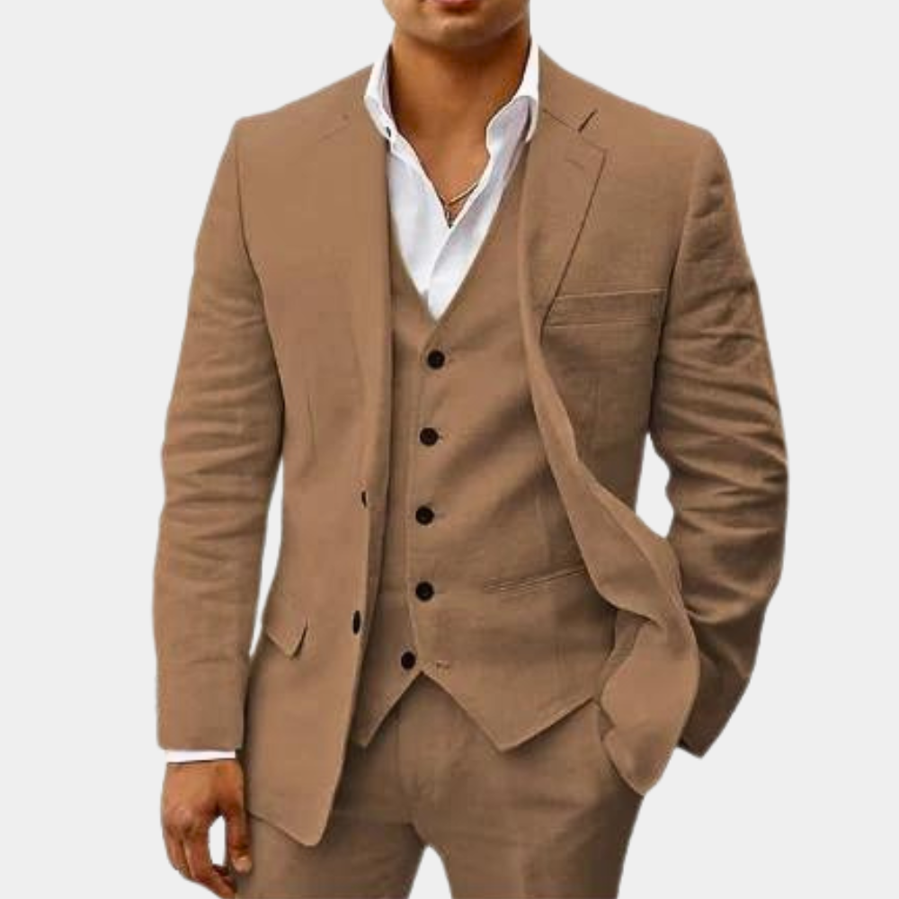 Model im beigefarbenen Dreiteiler aus Jacke, Weste und Hose mit weißem Hemd und dünner Halskette.