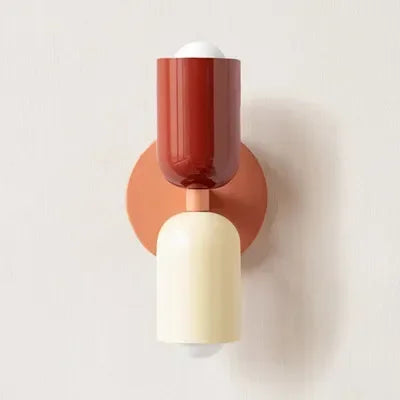 Einzelansicht der Wandlampe mit rotem Oberteil, cremefarbenem Unterteil und lachsfarbenem Wandteller vor heller Wand. 17