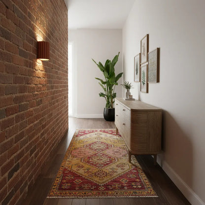 Terrakottafarbene Wandlampe an Backsteinwand in einem Flur mit Sideboard, Teppich und großer Zimmerpflanze 4