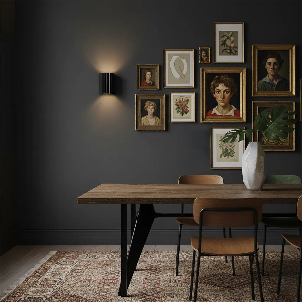Schwarze gerillte Wandlampe an dunkelgrauer Wand neben Bildergalerie, über einem Esstisch mit Holzstühlen 6