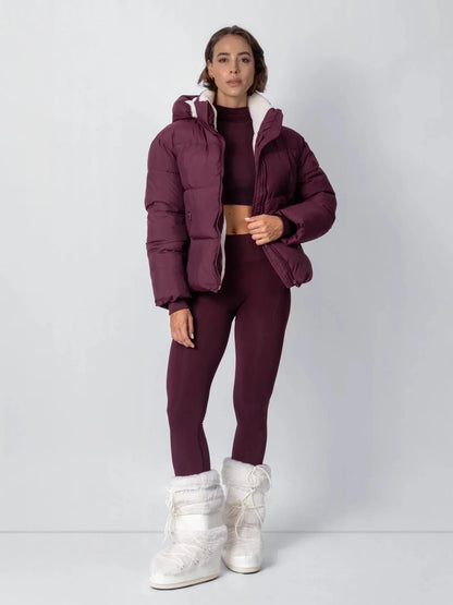 Ganzkörperfoto der bordeauxroten Steppjacke mit passendem Set und weißen Fellstiefeln 17