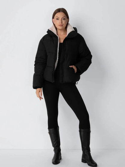 Ganzkörperansicht der schwarzen Steppjacke mit schwarzen Leggings und hohen schwarzen Lederstiefeln 13