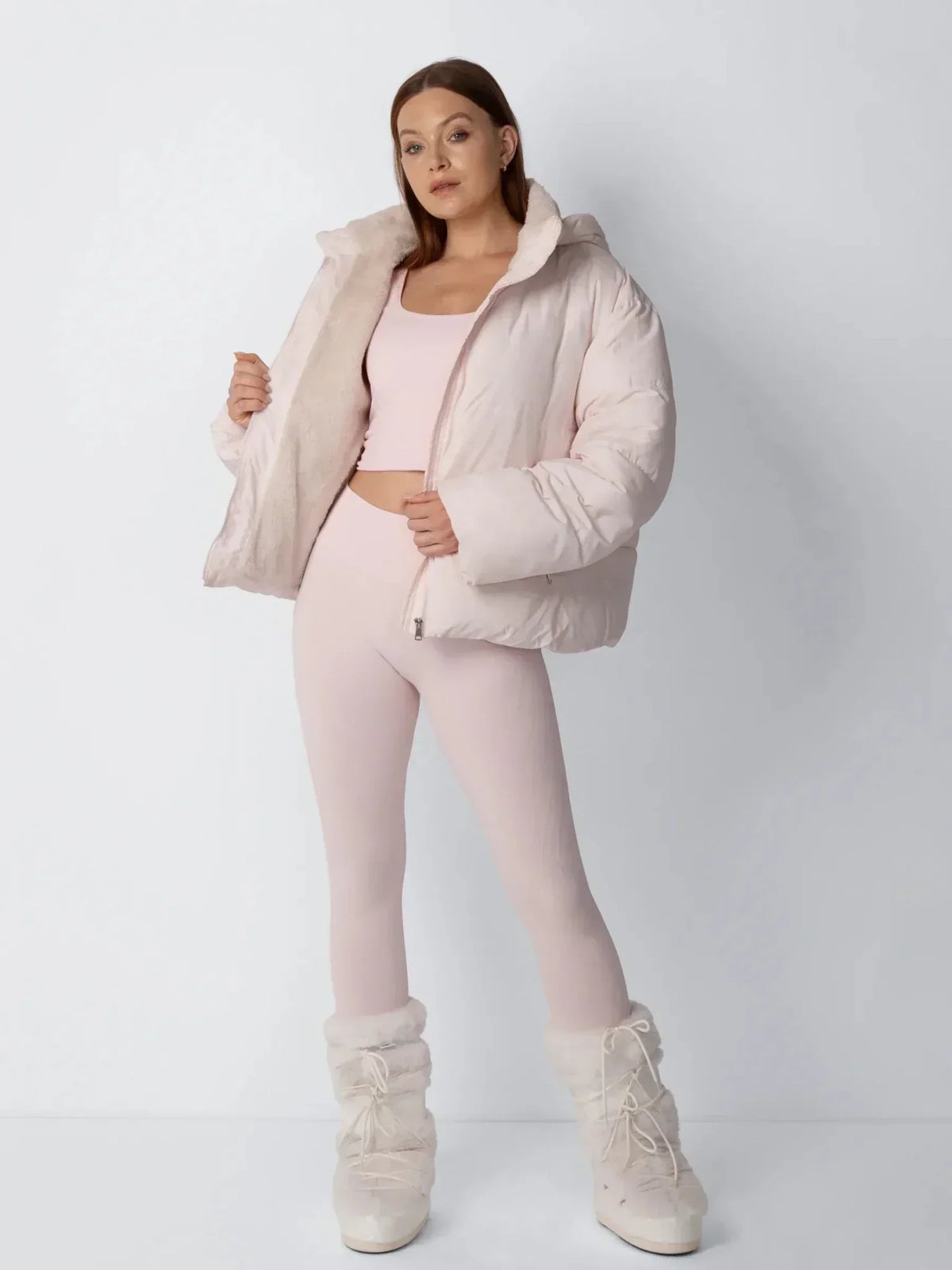Model in rosa Steppjacke öffnet die Jacke und zeigt das cremefarbene Fleecefutter, Ganzkörperfoto 8