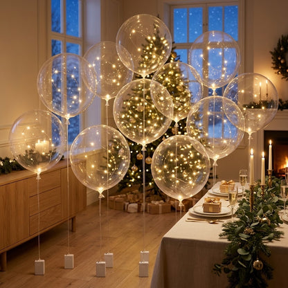 Mehrere Ballons mit warmweißen Lichtern schweben im festlich geschmückten Wohnzimmer vor dem Weihnachtsbaum 3