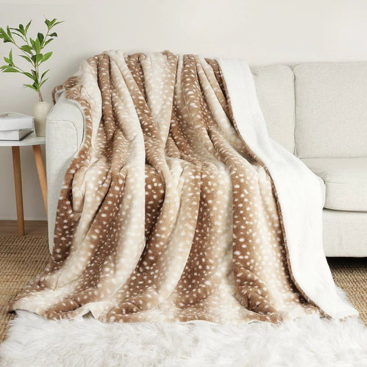 Braun-beige gepunktete Kuscheldecke liegt über einem hellen Sofa, die weiße Teddyfutter-Rückseite ist am Rand sichtbar. 1